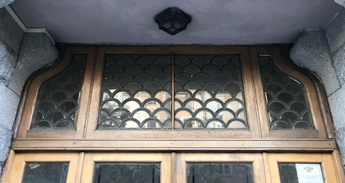 3-я линия, 52 к. 1. Фрамуга с фацетыми стеклами в латунном крепеже над дверью входа. Фото 2019